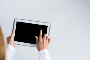 Pessoa apontando para a tela de um tablet.